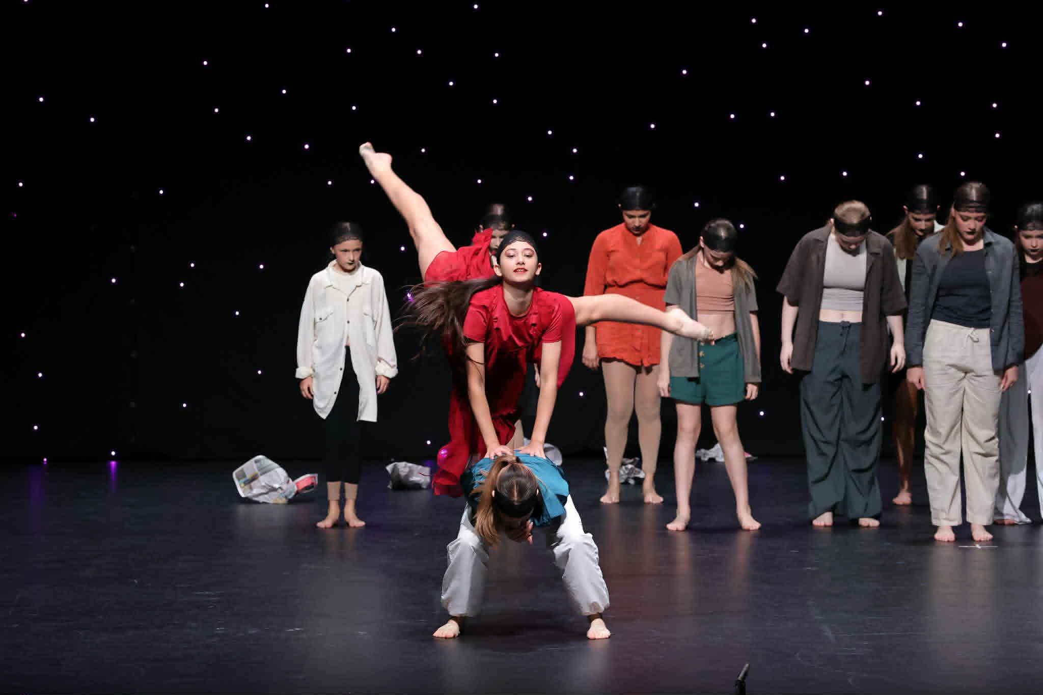 Stage Door Academy contemporary dancers performing a red costume lift on stage.